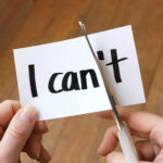 Close-up of hands cutting of paper to say I can instead of I can't